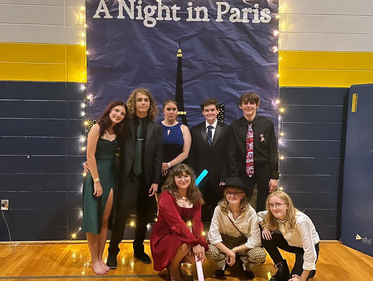 Left to right: Freshmen Gracie Koop, Carter Lewis, Kelsey Fender, Caleb Chadwick, Tyler Rafalski, Kaylee Klumpp, Ashley Keith and Brianna Keith come together to take picture in front of the Paris themed banner on Oct.15, 2023. Photo used with permission from Donny Velazquez.