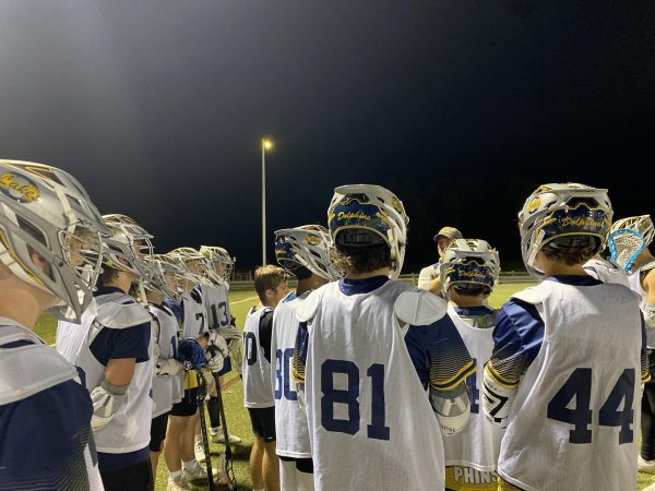 Boys lacrosse gather around as they listen to varsity coach Mark Keller share a pep talk during their game against OBX at Princess Anne Athletic Complex in Virginia Beach, VA, on Oct. 30,2023.
