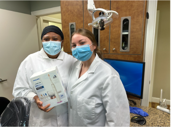 Evelyn Luma and Julia Candra hold a Sonic toothbrush on Oct. 30, 2023, at a family dentistry. Luma sponsors Ocean Lakes and donates both time and money to various efforts for students such as the ADC charity golf tournament.
