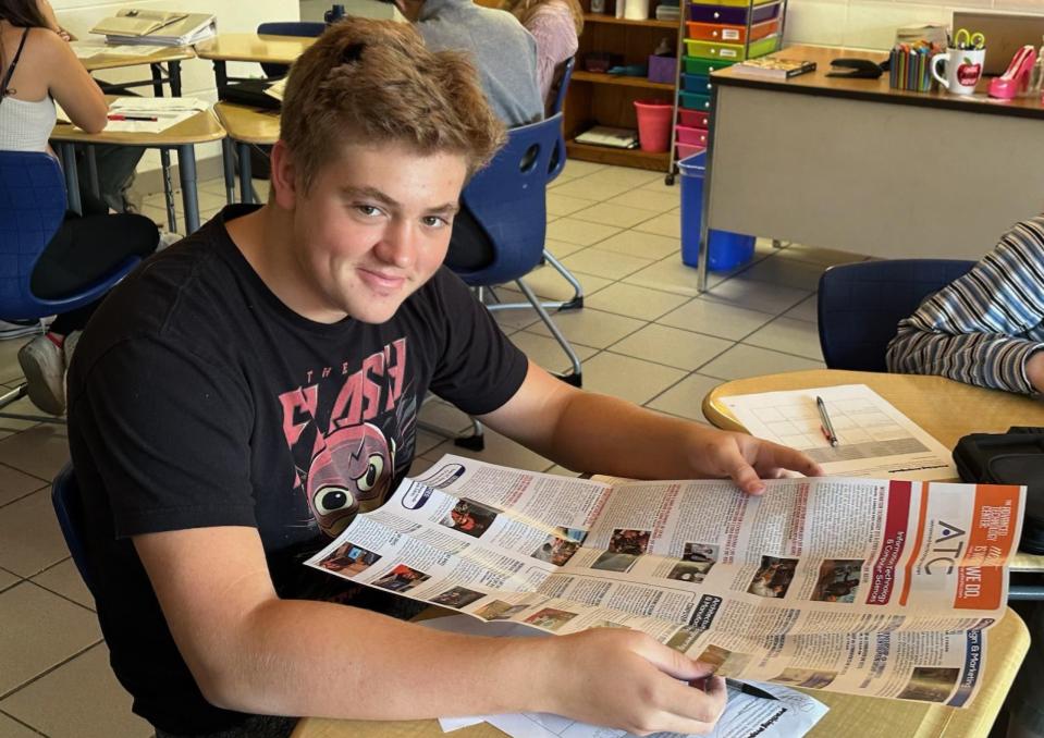 Freshman Tristan Meester scours the ATC pamphlet for course information in Room 127 during Honors English 9 on, Nov. 17, 2023. He is searching for courses to continue his ongoing ATC studies.