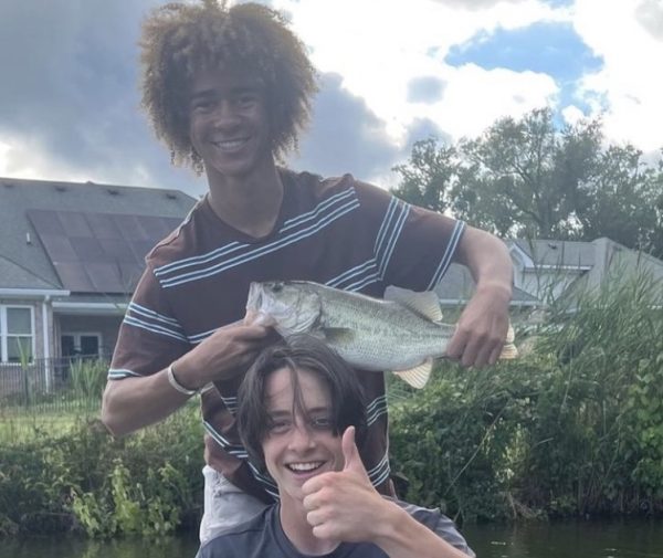 Aboubakr Sissoko and Caleb Tomberlin show off a freshly caught largemouth bass at Lagomar Lake on July 16, 2023.