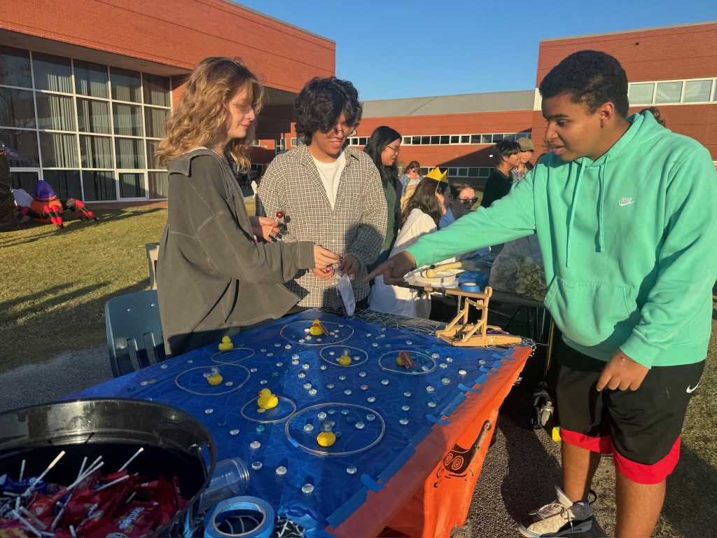 From left to right: Sophomore Reese Longwater and juniors Alex Joo and Dechaun Baker participate in the Latin club’s booth at Fall Fest on Oct. 30, 2023. At this booth, students got to collaborate with Latin club members and have fun at their booth.