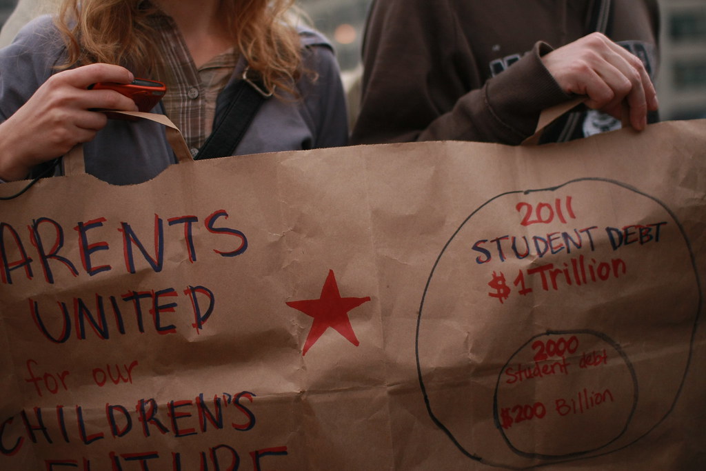 Photo shows the rising student debt in the United States and protests by parents for their children’s future. (Occupy Student Debt/Andra Mihali/Flickr/CC BY-SA 2.0)
