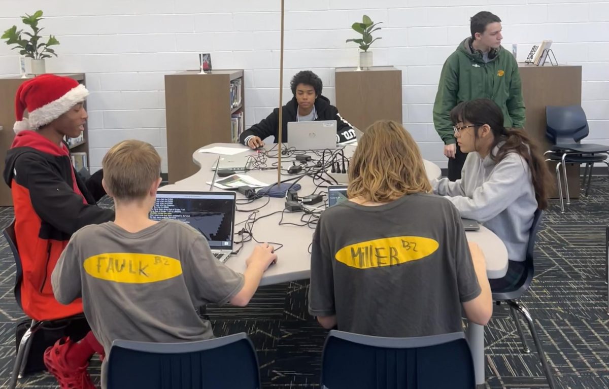 On Dec. 7, 2023, students use computer programming  to navigate their way through minecraft as one of the Hour of code stations. 