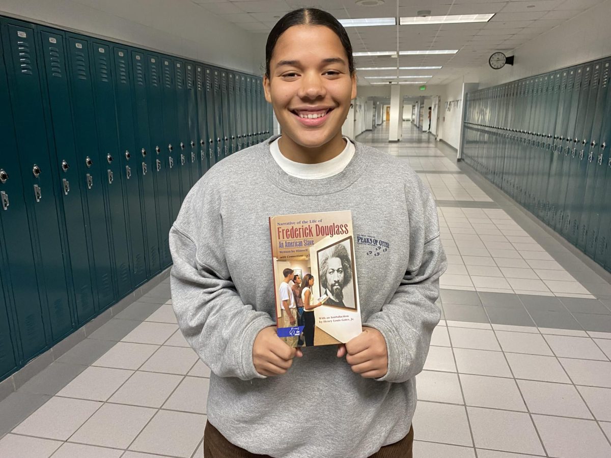 Junior Marlie Smith, who idolizes Douglass, holds a copy of his autobiography, “The Narrative of the Life of Frederick Douglass” on Feb. 12, 2024. Marlie and her other journalism classmates selected black history figures that have made significant strides in the arts, this years Black History Month theme.