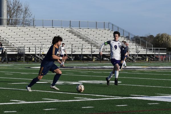 Senior Jesse Gutierrez runs with the ball while attempting to pass it to a teammate on Mar. 25, 2024, at Ocean Lakes High School. Photo used with permission from Sofia Pescoso.
