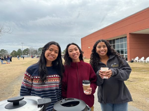 From left: Juliana Angeles, Chelsi Dizon and Sofia Thompson gather around as they enjoy hot chocolate at the winter bondfire on March 1, 2024.
