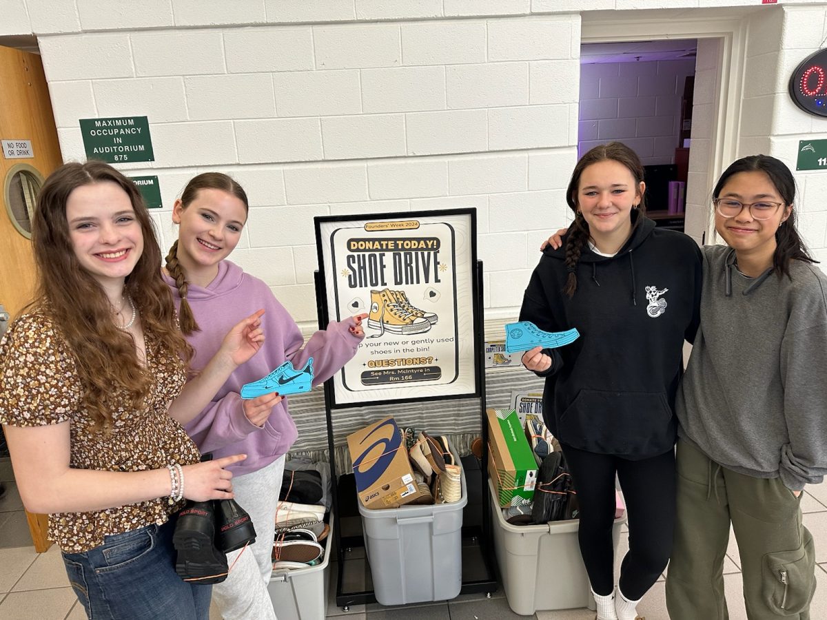 Freshmen Anna Lewis, Emilia McFarland, Acelyn Juhas and Naysa Doan flood bins with gently used shoes for Soles4Souls. Founders Week is full of reminders to be an upstanding member of the Ocean Lakes community.
