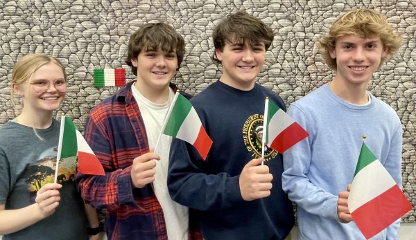 The Euro Challenge team with their country flag March 3, 2024. From left: sophomore and team captain Grace Kavanaugh, freshman twins Cole and Frankie Graninger, and sophomore Austin Stegerwald. Photo used with permission from Lisa Gibson.
