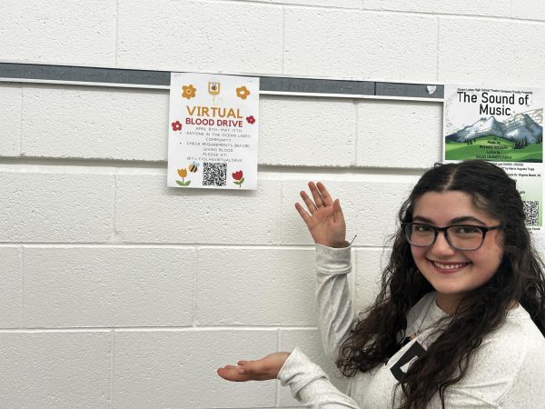Senior Hailey Bombard promotes the virtual blood drive poster in the gym foyer on April 22, 2024. Bombard is the co-blood drive committee chairman for National Honors Society. 