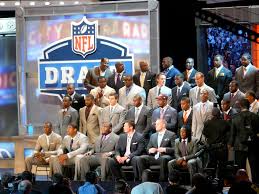 College prospects and 2011 NFL Hall of Fame Inductees invited to the 2011 NFL Draft prepare for a photo. Their professional football career begins here. (2011 NFL Draft Class Invitees and 2011 NFL Hall of Famers/Marianne O’Leary/CC-BY-2.0)