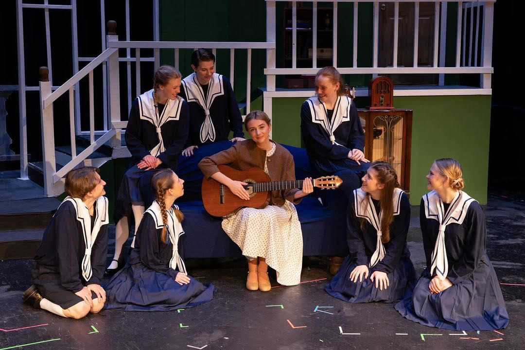 The Von Trapp children listen attentively as Maria teaches them to sing. The cast, ranging from freshmen to seniors, performed the entire play six times over the course of five days. From back to front, left to right: junior Lyla McGowen, senior Jae Cook, freshman Harper Magee, junior Andrew Friedman, freshman Abby Boomer, sophomore Anneliese Wedertz, junior Marty Hester and sophomore Grace Kavanaugh. Photo used with permission from Jared Swift.