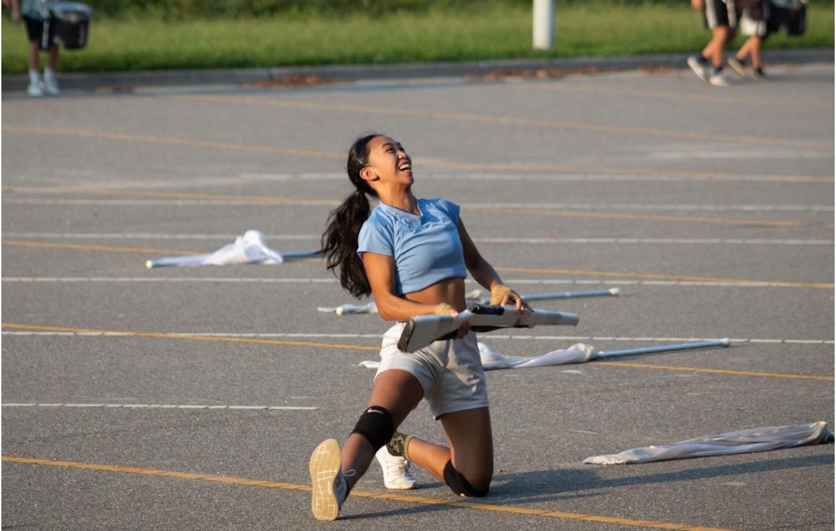 Senior and WAVE Visual Ensemble captain Chelsi Dizon catches the rifle during practice of "Beetlejuice" on Aug. 14, 2024, in the Ocean Lakes bus lot. 