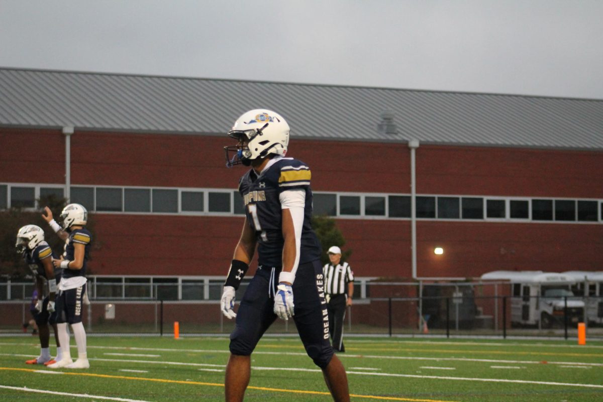 Senior Devin McGill lines up at the 20-yard line as the wide receiver before the center snaps the ball to senior quarterback Noah Colon. The Dolphins played Tallwood High School at Ocean Lakes High School on Sept. 13, 2024. Ocean Lakes was victorious with an ending score of 43-19.