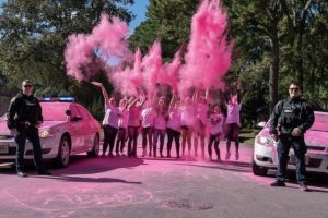 Participants of the Abby Furco Color Run celebrate with a burst of pink power, filling the air with color and joy. Two Virginia Beach Police Department officers stand in support on Oct. 20, 2024 at Lago Mar Park. Photo used with permission from Eric Aamodt. 
