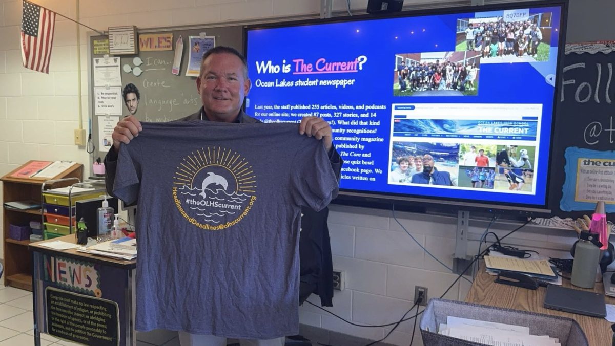 Dr. Donald Robertson embraces a t-shirt from The Current, gifted to him after his interview on Oct. 11, 2024, in Room 127. Robertson visited Fara Wiles’ journalism class to help students learn what a superintendent does and what it takes to lead a district.