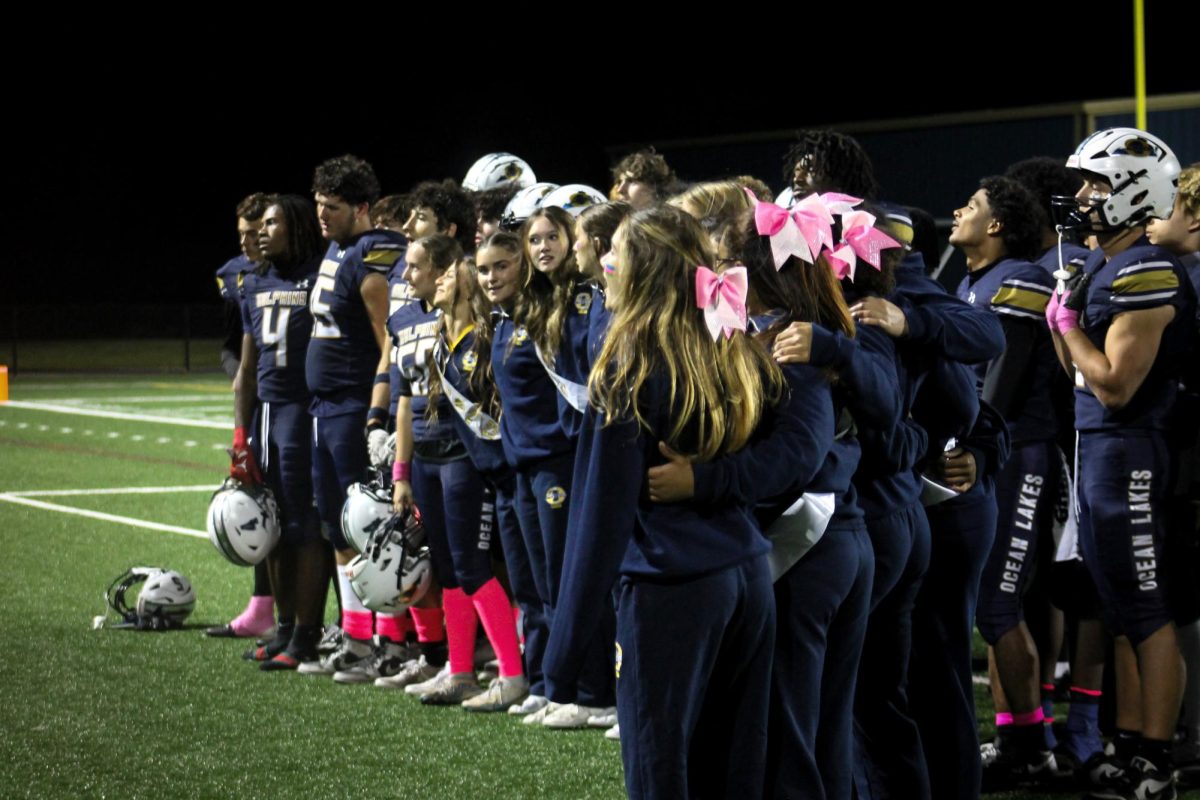 Ocean Lakes varsity football and cheer teams gather for a picture after a tough 23-15 loss to the Kempsville Chiefs on Oct. 10, 2024. Both groups celebrated their senior night that same evening. 