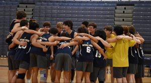 Boys volleyball form a team huddle before taking home another win with a score of 3-0 against the Green Run Stallions at Ocean Lakes High School on Oct. 8,2024. Photo used with permission from Syd Critcher. 