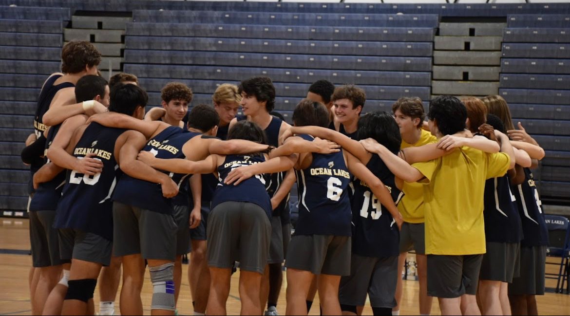 Boys volleyball form a team huddle before taking home another win with a score of 3-0 against the Green Run Stallions at Ocean Lakes High School on Oct. 8, 2024. Photo used with permission from Syd Critcher. 