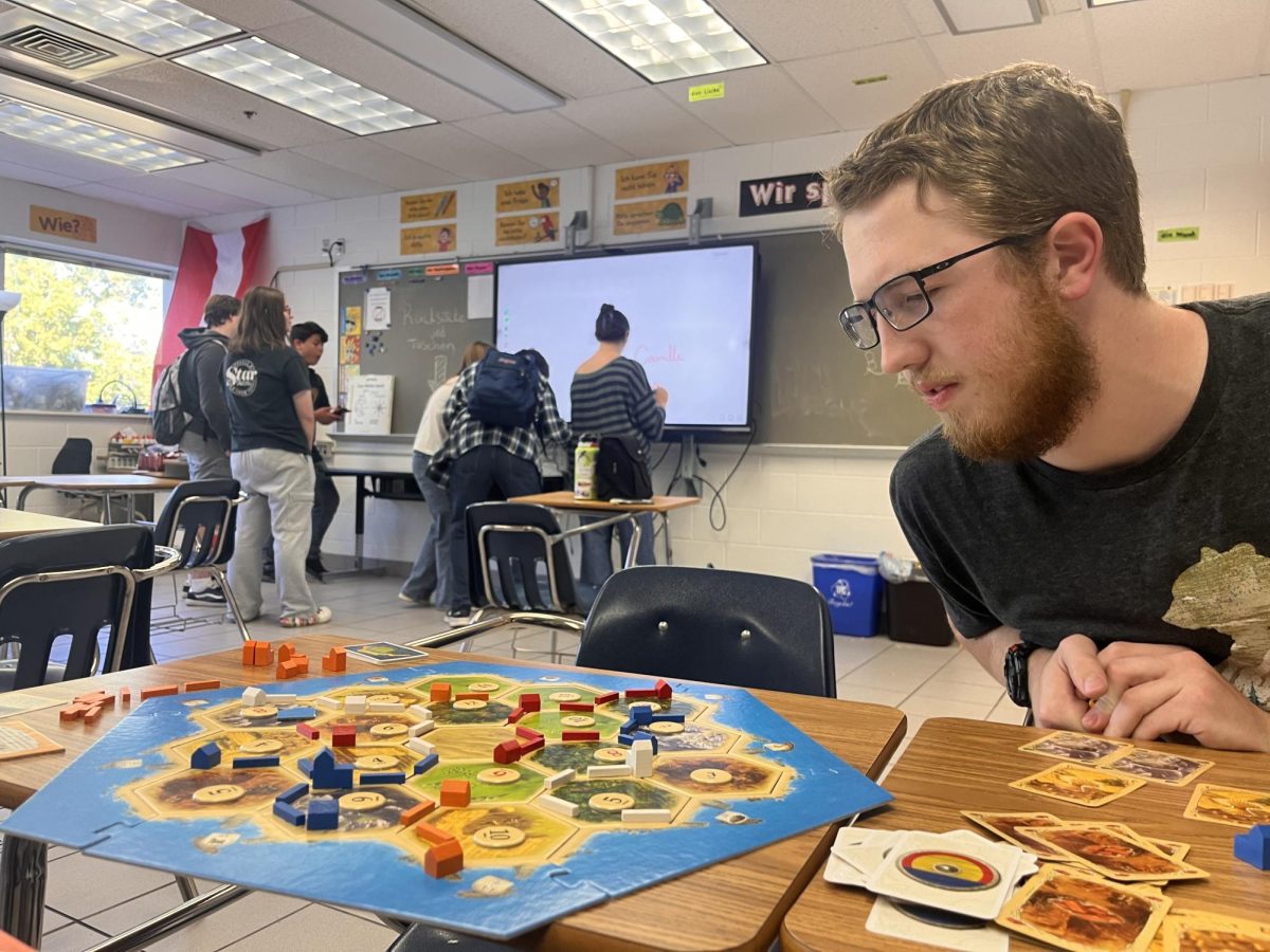 Juniorr Colin Gregory anchors his attention, on his next move in Catan on Oct. 23, 2024, in room 253. Catan was originally invented in Germany but has expanded globally and can now be found in over 50 languages, according to vitabrevis.americanancestors.org. 