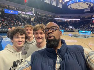 From left to right: Mario Mullen, James Cummings, Owen Wilbricht and Nash Phillips take a selfie at an ODU game on Jan. 27, 2024. Mullen was honored during the game as an ODU alumnus and former player on the men’s basketball team. Coach Mullen was known for going the extra mile, often initiating team bonding activities with his high school athletes, as pictured. Photo used with permission from James Cummings.