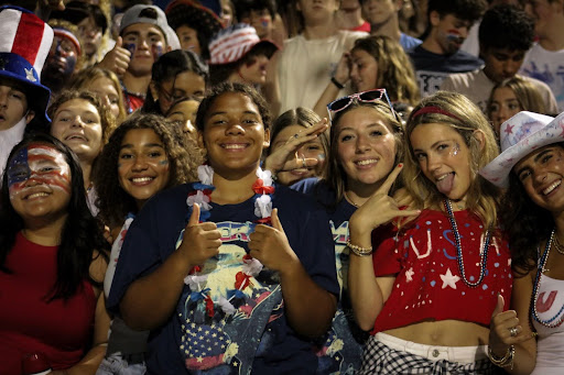 From left to right: Seniors Gillian Gutierrez, Khadija Sissoko, Marlie Smith, Hailey Dickerson and Emma Bane showcase school spirit in the student section on Sept. 6, 2024. The Dolphins faced First Colonial High School with a score of 51-7.