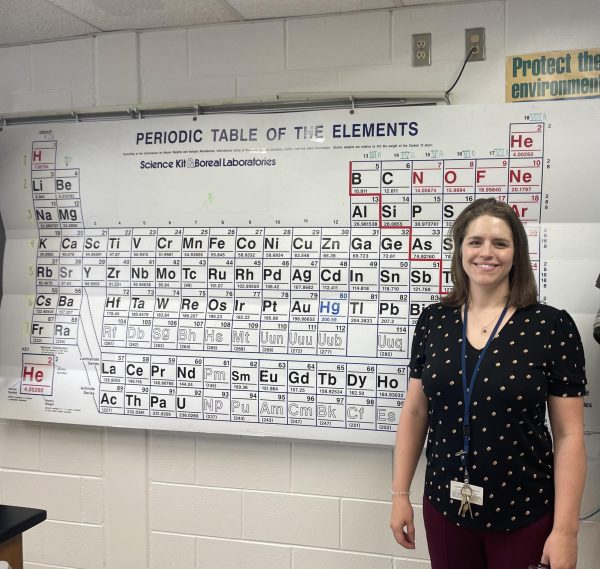 Jennifer Estabrook stands next to the Periodic Table of Elements in room  230 at Ocean Lakes High School on Oct. 14, 2024. 
