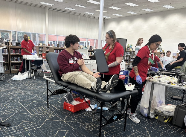 American Red Cross nurse prepares senior Antonio Kati for his donation on Dec. 17, 2024, in the library. Donors are required to undergo a mini-physical prior to donation.
