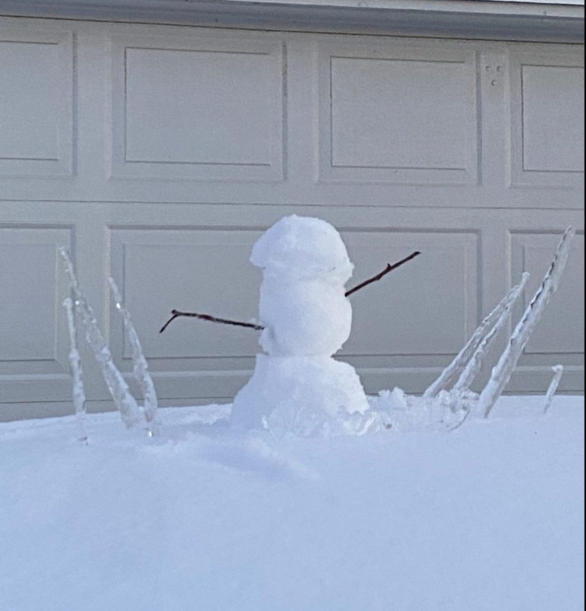 A freshly constructed snowman rests in front of a garage door in Sawyer Lakes, Virginia Beach on Jan. 22, 2025.