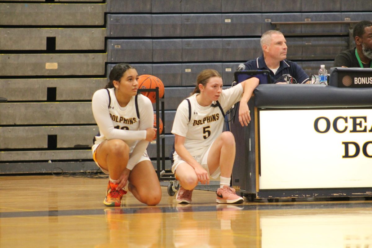 Sophomore Kennedy Walls and senior Madeleine Fisher prepare to sub in against rival Kellam High School on Dec. 13, 2024, at Ocean Lakes High School. The final score was a slight defeat of 68-43. 