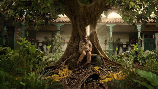 Jose Arcadio Buendia (Diego Vasquez) is tied to a tree in the Buendia courtyard after going insane. In the series, fate leads each character to eventual solitude with Jose Arcadio Buendia as the first instance. Courtesy of Netflix.