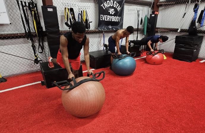 From left to right: junior Jamarie Sanders, freshman Jonathan Washington Jr., and junior Antonio Oseguera doing elevated isometric push ups. Photo taken at TNDO gym on February 4th, 2025. Photo used with permission by Sean Defendi.