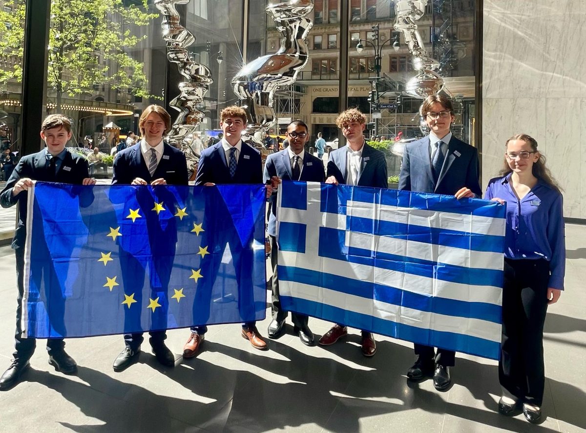 From left to right: Sophomores Robert Hunt, Phoenix St James, Stone Wagner, Zaid Muhammad, Logan Saltisiak, Andrew Koivu and Esther Gammill hold the flag of Europe and Greece. Picture taken in the lobby and on Apr. 28, 2025. Photo used with permission by Lisa Gibson.
