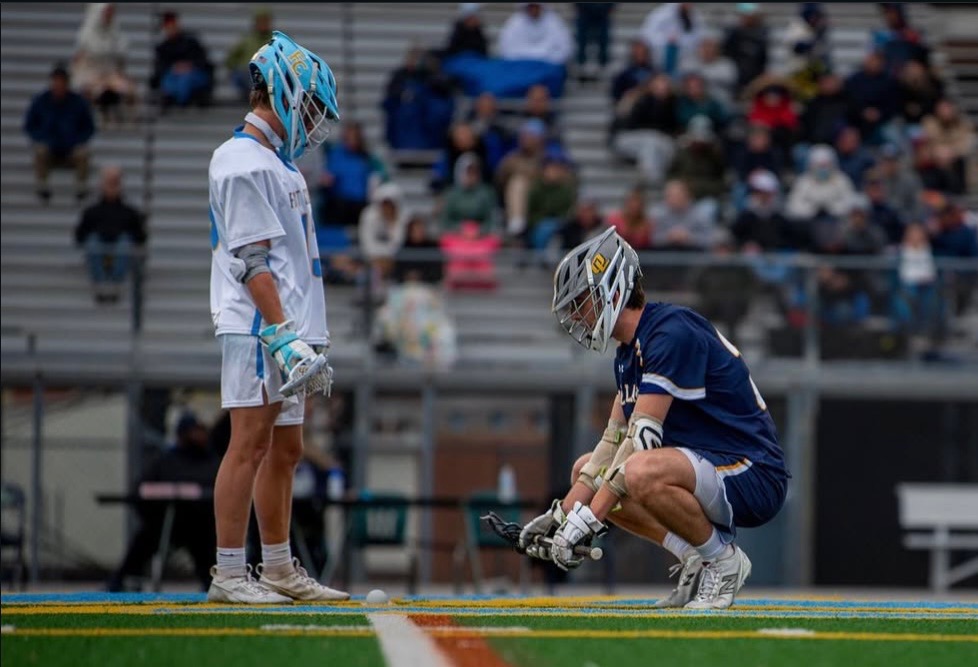 Daniel Shattuck lines up for a faceoff with a First Colonial player. The Dolphins went on to win this game on April 10, 2025 by a score of 9-6.