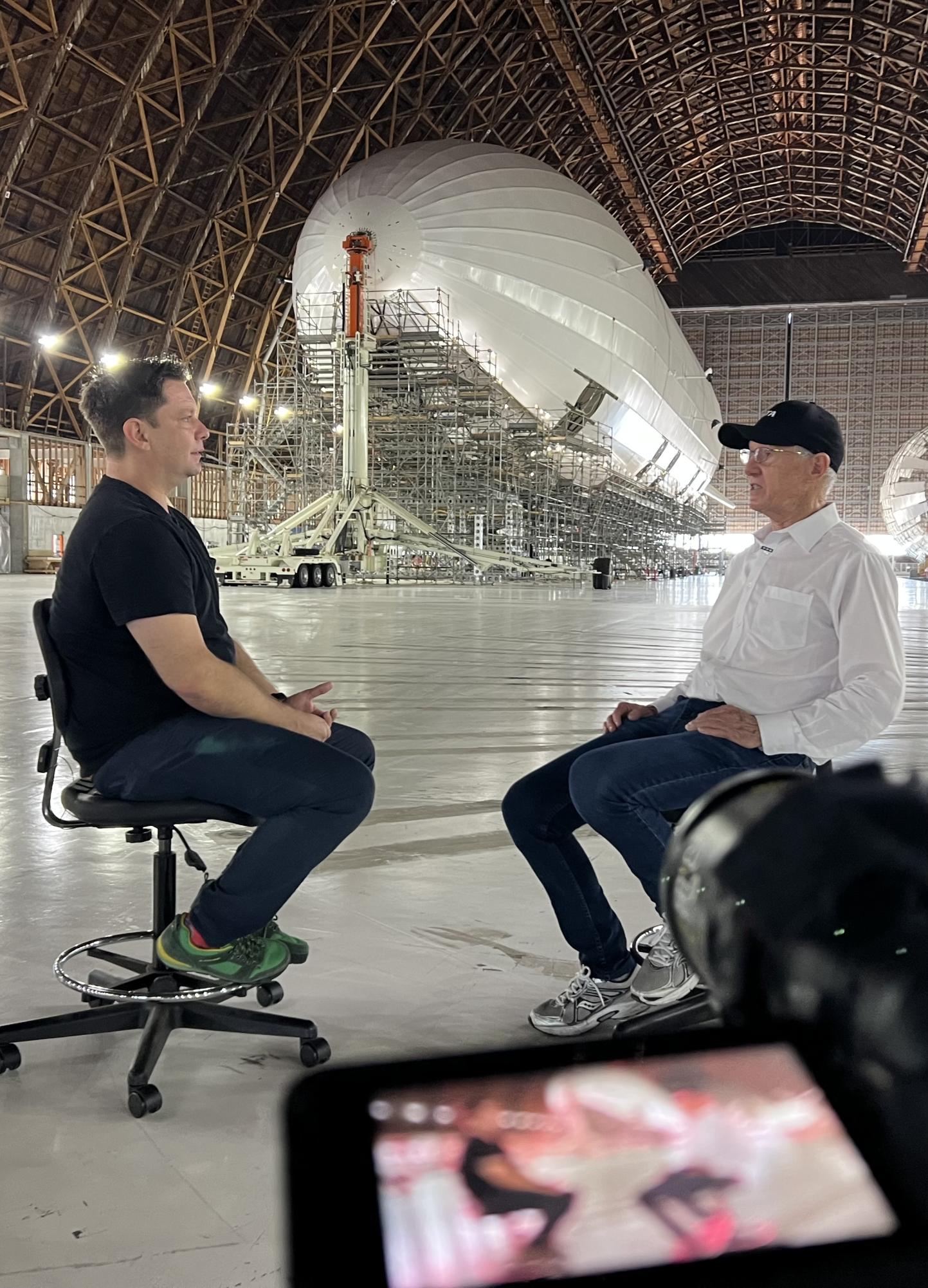 Ashlee Vance speaks with an aerospace engineer on August 16, 2022 at Moffett Federal Airfield. To put together his books and videos, hundreds of interviews go on behind the scenes. Photo used with permission from Ashlee Vance.