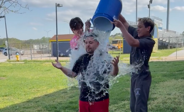 Wrestlers Aidan Nichols and Chris Castillo dump a bucket of ice water on their wrestling coach Michael Mosley. The event took place outside of the gym after school practice.