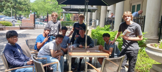 Pictured from left to right: sophomores Juno Paguiligan, Eeshan Desai, Marshall Shoemaker, Tulga Rentsendorj, Chris Litto, Stone Wagner, Tyler Rafalski, Vihaan Shah and Brayden Knowles sit outside for lunch on May 16, 2025 at the Chrysler Museum in Norfolk, Virginia. The students went on an AP Euro field trip to observe various pieces of artwork. Photo courtesy of Sam Pili. 