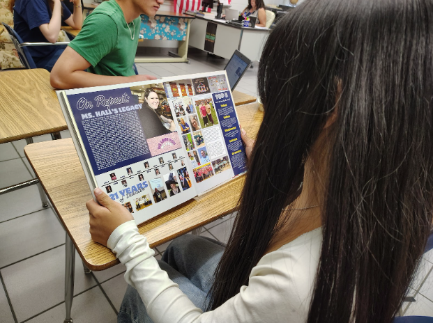 Sophomore Zaisha Ipac reads the two-page dedication to Shirley Hall in the yearbook. It appeared on page 222-223.