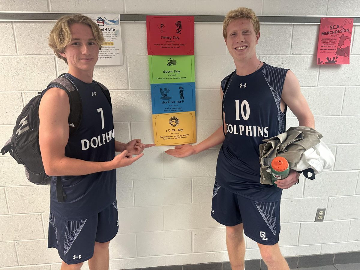 Pictured from left to right: Juniors Van Helgren and Zak Kain-Kuzniewski present the spirit week themes on August 26, 2025. The school wide event will take place from Sep. 2 to Sep. 5 with the themes of Disney Day, Sport Day, Surf vs. Turf Day, and OL Spirit Day.