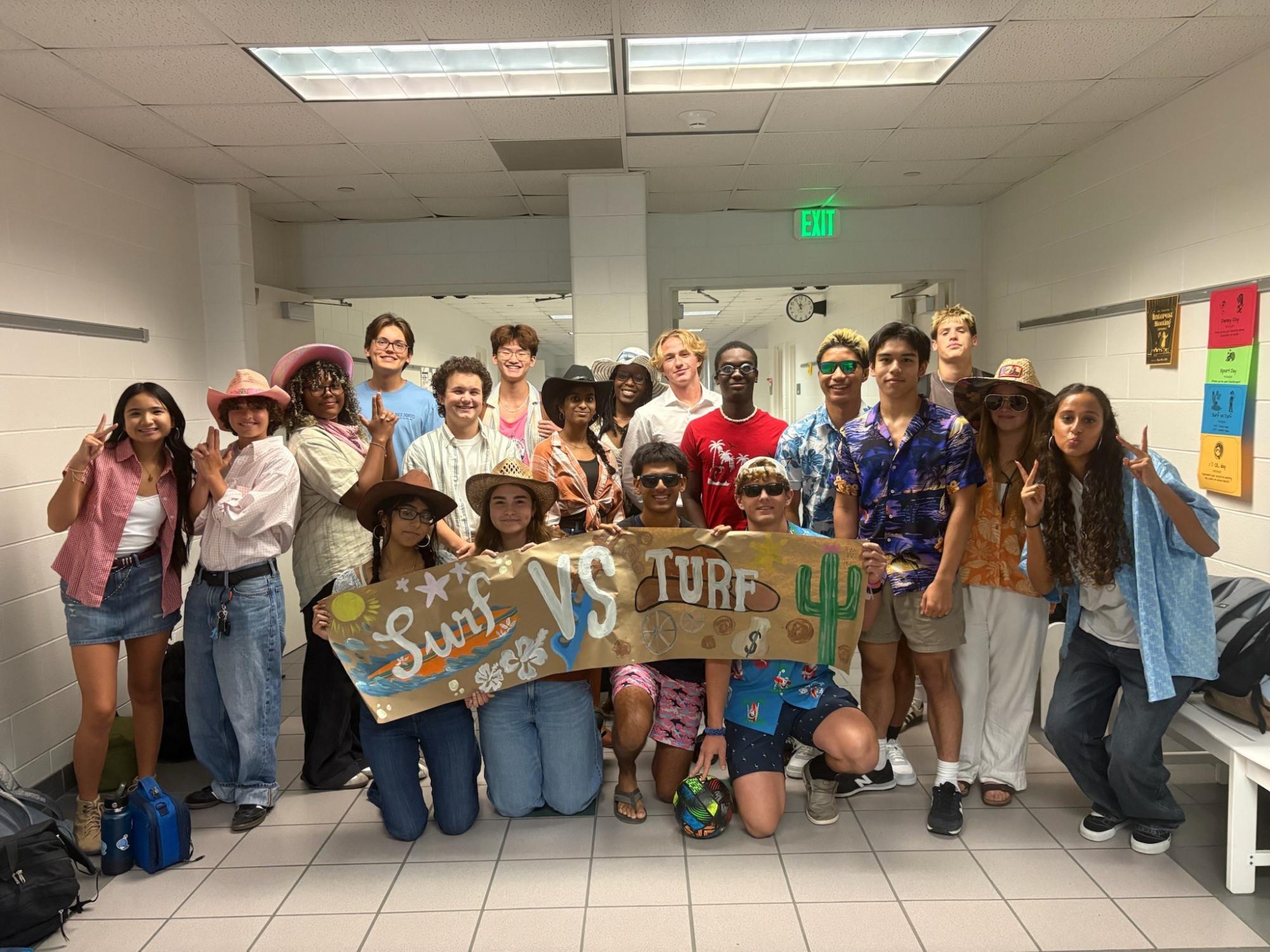 Class of 2027 pose with the surf vs. turf day banner made by Kamie Santos. The group is dressed as surfers and cowboys on the final day of the competition, Sept. 10, 2025. Photo used with the permission of Kamie Santos.