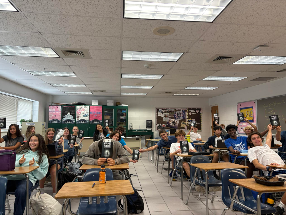 Cross country holds up copies of the book, “Win in the Dark,” during a Thursday book club meeting. They read and discussed how to "get the ball rolling." Image used with permission from Michael Nestor.