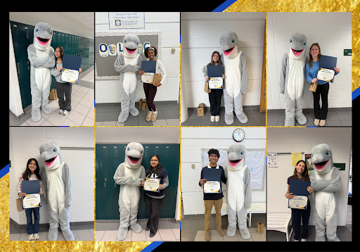 Penelope Aujero, Arianna Watson, Nicole Nanocchio, Charlotte Strunk, Aarna Aithani, Sarah Talur, Vihaan Shah, and Emilia Fiorentine stand with school mascot Spirit the Dolphin. Each student displayed their awards for December's Student of the Month: Culturally Competent Citizen. These photos were taken by Jenna Filipowicz on Jan. 8, 2026. 
