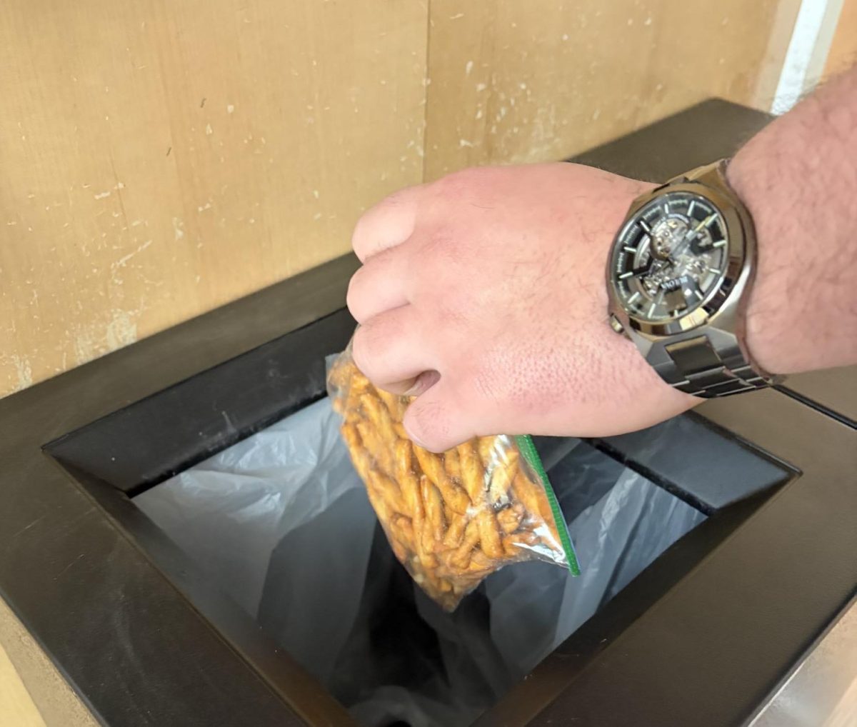 A student throws out an untouched bag of pretzels during lunch on Mar. 4, 2026. Approximately 330 to 356 million pounds of food is wasted every day in the United States, according to Recycling Tracking Systems. 