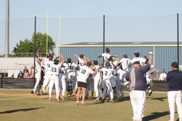 Senior Donovan Nagle celebrates with his team after hitting his first home run in his high school career at Ocean Lakes High School on May 12. This led the Dolphins to a 7-run lead.