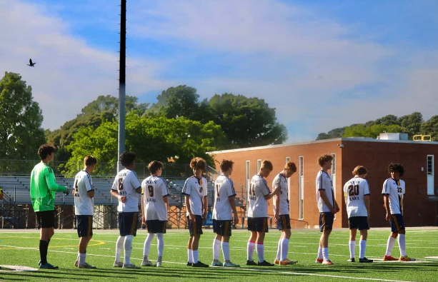 The team stands at the center of the field as the National Anthem plays, leading to their away game against Kempsville High School on  May 5, 2026. The team tied the game 1-1. Photo used with permission from Caleb Gonzalez.
