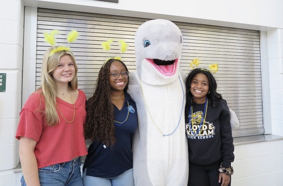 Pictured from left to right: Hattie Smith, Tameya Norton, Colt Walker and Brooke Bullock crowd around Colt Walker as Spirit the Dolphin. This was taken prior to the Spring Spirit Assembly during which Spirit’s identity was revealed.