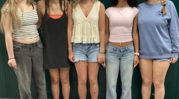 Erin Broderick, August Bridges, Breahna Martin, Desiraye Taylor and Maya Phillips line up in the hallway showing off their outfits. The outfits highlight many trends from the past including the baggy jeans and over-sized sweatshirts.