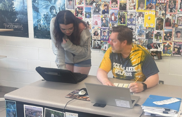 English teacher Don Kroeller helps sophomore Aubrie Ballweg on her Joy Luck Club Heritage Project in Room 123 during block 4B. The Joy Luck Club Heritage Project requires students to analyze the novel's themes and share their own family history.